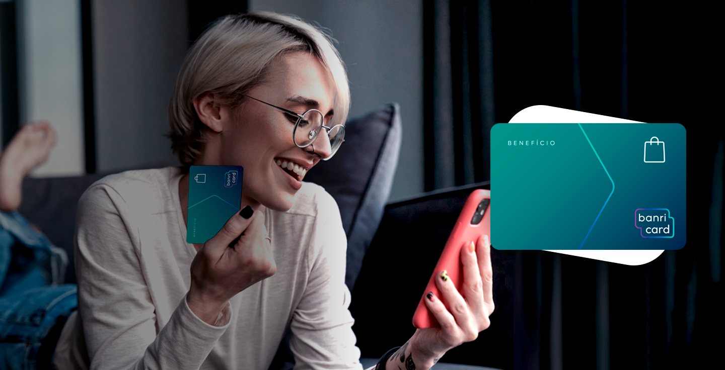 Foto de uma mulher pagando com o Banricard benefício pelo celular.